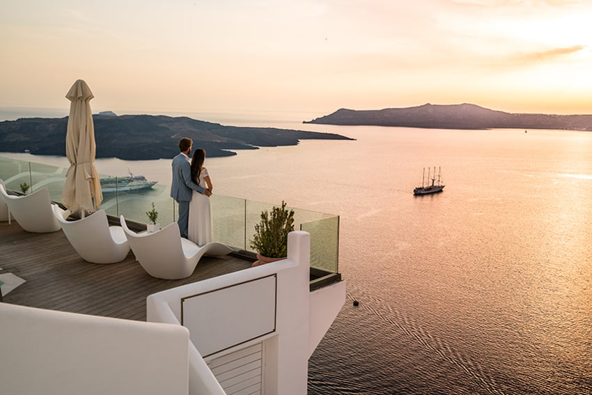 바다가 내려다보이는 로맨틱한 그리스 럭셔리 호텔에 함께 있는 연인.
